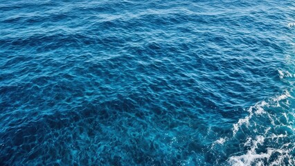 Obraz premium A serene view of deep blue ocean waters with gentle waves and sunlight reflections.