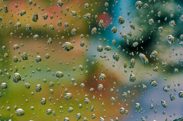 Drops on the glass and focus on them, the surrounding world is blurred behind the glass, a natural beautiful abstract picture has been created