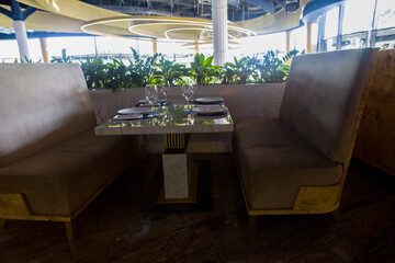 modern table setting in a trendy restaurant. Sofa, armchair, table and dishes on the table