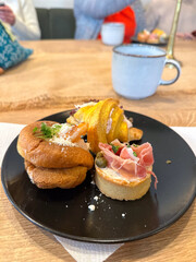 Gourmet appetizers elegantly arranged on black plates. Colorful presentation and variety of flavors, luxurious dining experience. Food and buffet concept