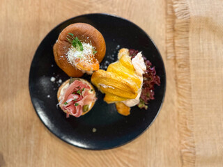 Gourmet appetizers elegantly arranged on black plates. Colorful presentation and variety of flavors, luxurious dining experience. Food and buffet concept. Top view