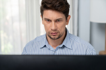 Casual outfit businessman looking report on pc screen, analyzing to create marketing plan to analyze new customer target on social media channel web page online promotion at modern office. Postulate.