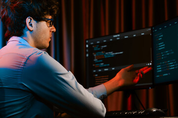 Working IT developer concentrating online software development information on surrounded by coding application pc screens, creating program for firmware on website at neon modern office home. Gusher.