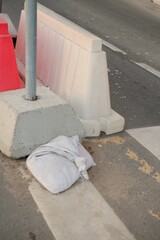 Red, white plastic safety barriers along roads. Ensuring road safety with visible barriers. measures during roadside work. pedestrian crossing is being repaired on city street residential buildings.