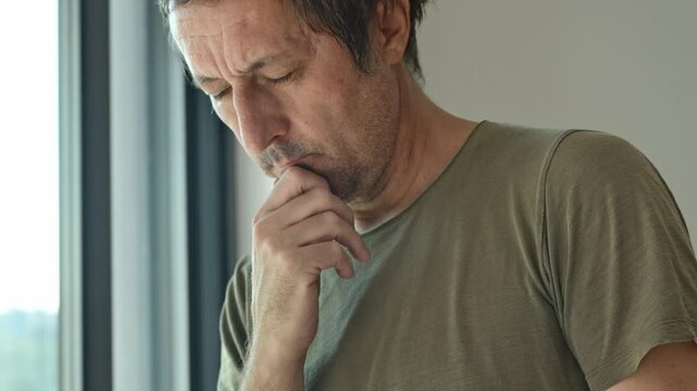 Headshot portrait of mature adult male thinking and looking out the window, 4K