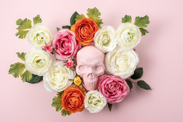 Creative Halloween layout made of pink skull with flowers on pink background. Minimal holiday concept.