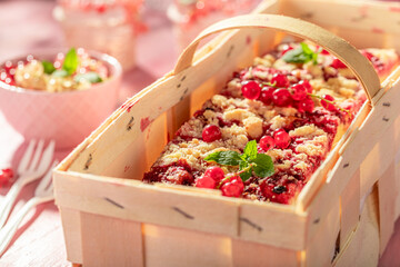 Hot red currant yeast cake freshly baked on pink table.