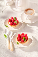 Sweet mini tart made of cream and raspberries.