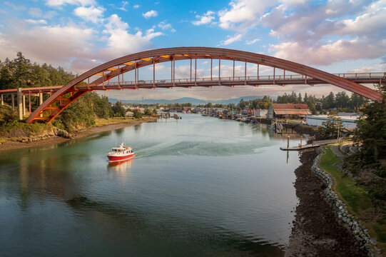 Historic Rainbow Bridge in the tourist town of La Conner, Washington with a boat passing underneath. The bridge connects the town to the island that is part of the Swinomish Indian Reservation. 