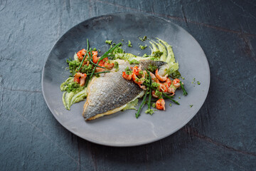Fried cod fillet with mashed potatoes, fresh prawns and marsh samphire served as close-up on a Nordic design plate with text space