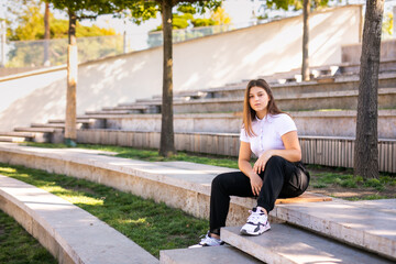 A 16-year-old girl in a school uniform sits on the steps of the street