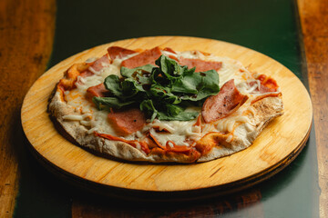 A delicious pizza is sitting on a wooden plate located on a table