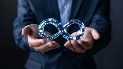 Fototapeta premium Businessman holding a digital infinity symbol, dark background.