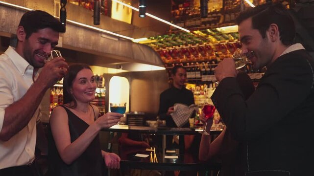Man with couple standing fronted bar while friend walking to cheers cocktail in Paloma, Margarita, Old fashioned and Martini while bartender making special party beverage vibrant nightclub. Vinosity.