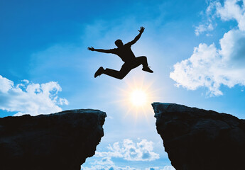 Silhouette of a man jumping over a chasm with a sun and blue sky, symbolizing success and overcoming challenges, wide-angle, ultra-realistic 3D concept.