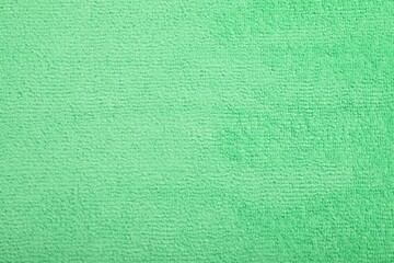 Light green microfiber cloth as background, top view