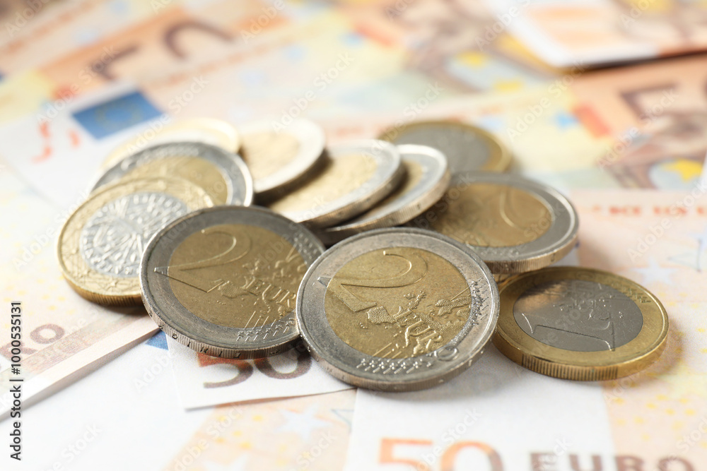 Wall mural Many coins on euro banknotes, closeup view