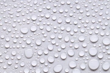 Water drops on light gray background, top view