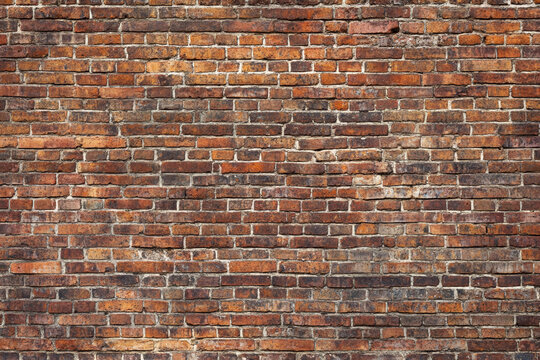 Red brick wall background with visible textures and patterns, perfect for creative projects or adding a nostalgic and timeless touch to any space.