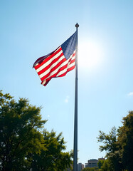 American flag soaring high above trees under a bright sky