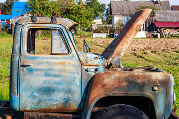 Cabin of an old rusty truck abandoned in the backyard