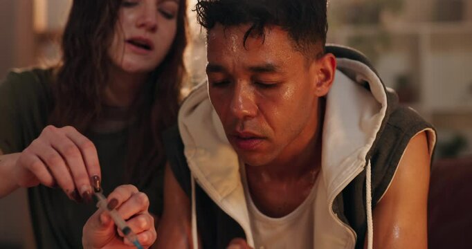 Heroin, injection and couple with addiction in home for substance abuse, overdose or needle opoids. Spoon, syringe and flame lighter for cocaine craving with people together at illegal drug house.