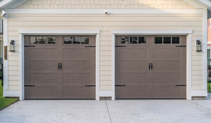 Brown electronic garage doors transom light windows on a double garage driveway with pink...
