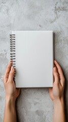 Hands holding a blank notebook, ready to write the next chapter, soft focus background, New beginnings, career planning