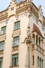 Fototapeta premium Sculpture in form of the Roman legionnaire slaying dragon on corner of building in old part of Prague in Czech Republic