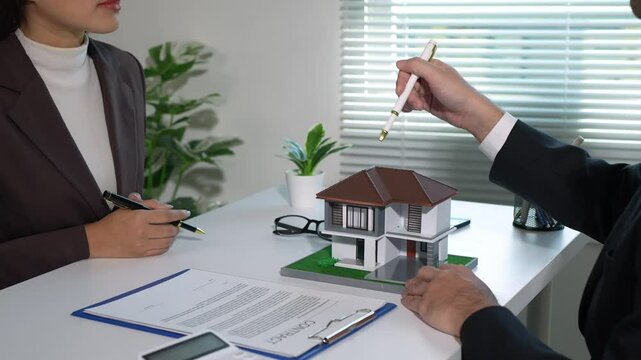 Real estate agent, collateral hire purchase, land and house broker manager, sit down to discuss details, sign contracts, and place a deposit with customers in the agent's office.