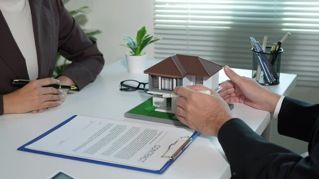 Real estate agent, collateral hire purchase, land and house broker manager, sit down to discuss details, sign contracts, and place a deposit with customers in the agent's office.