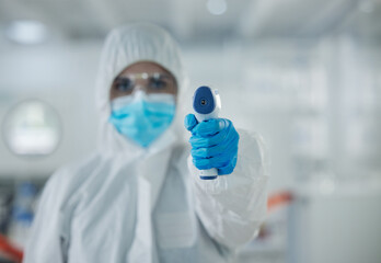 Scientist, portrait and thermometer with hazmat suit for temperature, health and safety check at...