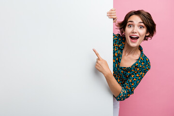 Photo of astonished girl with bob hair dressed stylish shirt directing at sale on billboard empty...