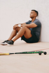 Athlete, man and relax with racket on court from squash competition, fitness stress and sports...