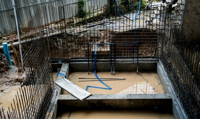 A construction site displaying a reinforced concrete foundation with steel rebar