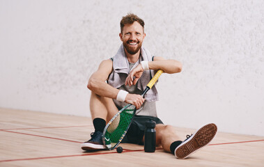 Portrait, man and rest for sports in court with squash racket, fitness game and exercise...