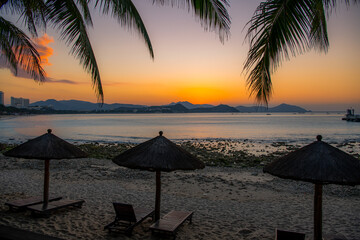 Beach daybeds and the palm trees at Dadonghai beach, Sanya, China