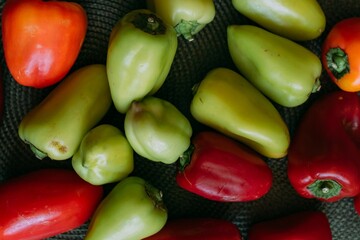 Ground pepper is red and green on the wooden table on a green napkin for a plate. Green and red bell peppers on a green textured placemat. Harvesting vegetables for the winter. Cooking stuffed peppers
