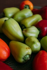 Ground pepper is red and green on the wooden table on a green napkin for a plate. Green and red bell peppers on a green textured placemat. Harvesting vegetables for the winter. Cooking stuffed peppers