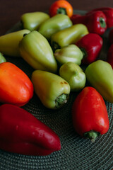 Ground pepper is red and green on the wooden table on a green napkin for a plate. Green and red bell peppers on a green textured placemat. Harvesting vegetables for the winter. Cooking stuffed peppers