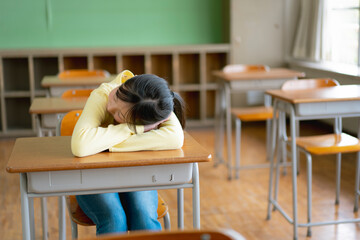 教室の中で寝ている女子小学生