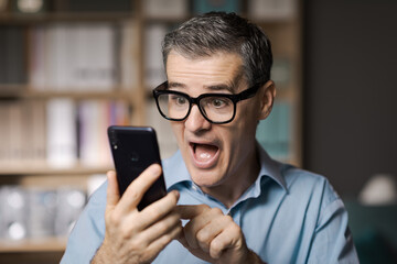 Happy businessman checking his smartphone