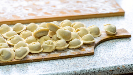 Homemade dumplings close-up. handmade dumplings on a wooden board, selective focus, tinted image, traditional Russian dish,