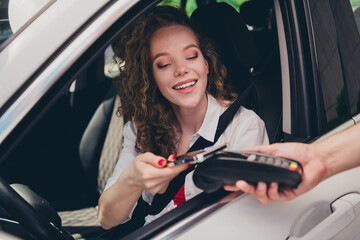 Photo of charming positive woman wear white shirt paying modern device terminal driving auto...