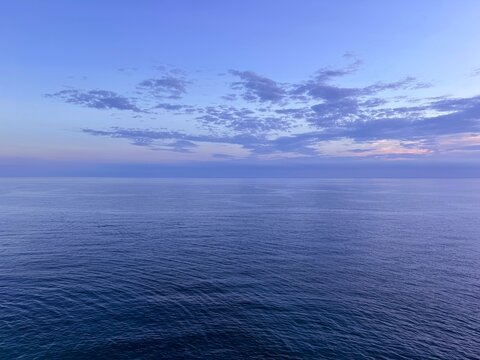 Ocean water calm ripples surface and dark clouds in the sky at evening.