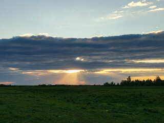 Fototapeta premium Field with a large cloud in the sky