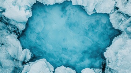 Aerial view of a serene ice formation showcasing a clear blue water pool surrounded by icy edges.