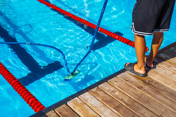 People cleaning the pool with a suction hose. Close up of a person cleaning the pool with a vacuum...