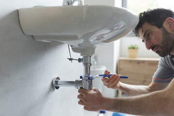 Professional plumber fixing a sink