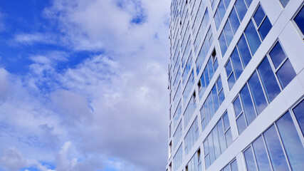 Fototapeta premium Exterior of a high modern multi-story apartment building - facade, windows and balconies.